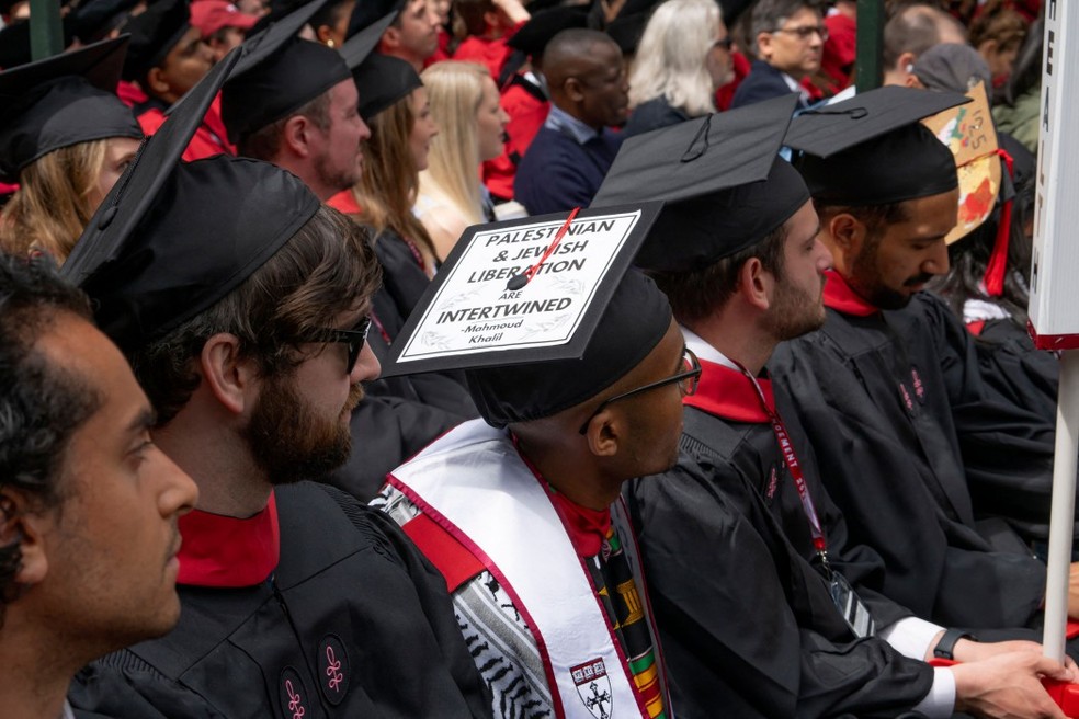 O chapéu de formatura de um estudante exibe uma citação do líder estudantil pró-palestino da Universidade de Columbia, Mahmoud Khalil, detido na 374ª cerimônia de formatura de Harvard, em Massachusetts — Foto: Rick Friedman / AFP