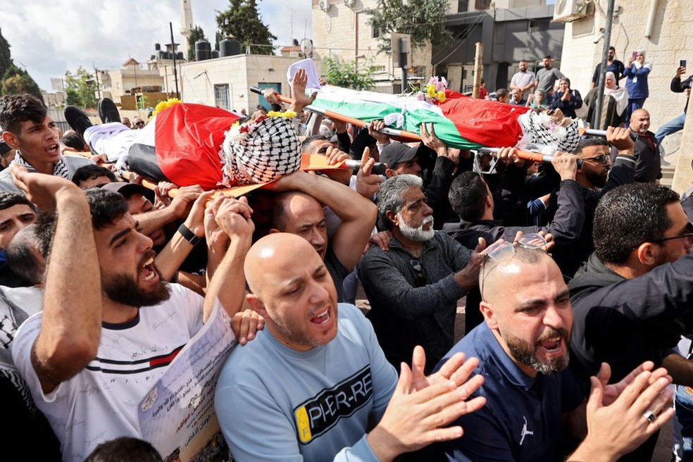 Cena que se repete na Cisjordânia: homens carregam corpos de jovens palestinos mortos em confrontos entre colonos e forças israelenses — Foto: Jaafar ASHTIYEH / AFP