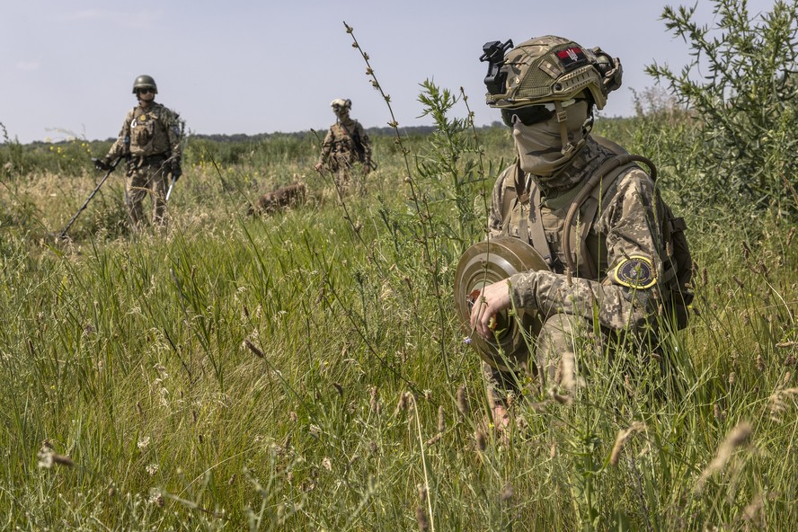 Soldados ucranianos da unidade de detonação de minas da 102ª Brigada de Defesa Territorial carregam minas antitanque inativas durante exercícios de treinamento perto da cidade de Huliaipole, na região de Zaporíjia.
