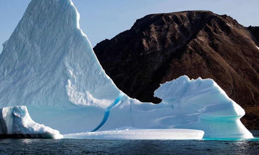 Iceberg perto da ilha de Kulusuk, na costa sudeste da Groenlândia. Aquecimento global causado pelas atividades humanas terá consequências dramáticas para os oceanos e a criosfera, que inclui gelo marinho, geleiras, calotas polares e permafrost (tipo de solo encontrado na região do Ártico, constituído por terra, gelo e rochas permanentemente congelados)