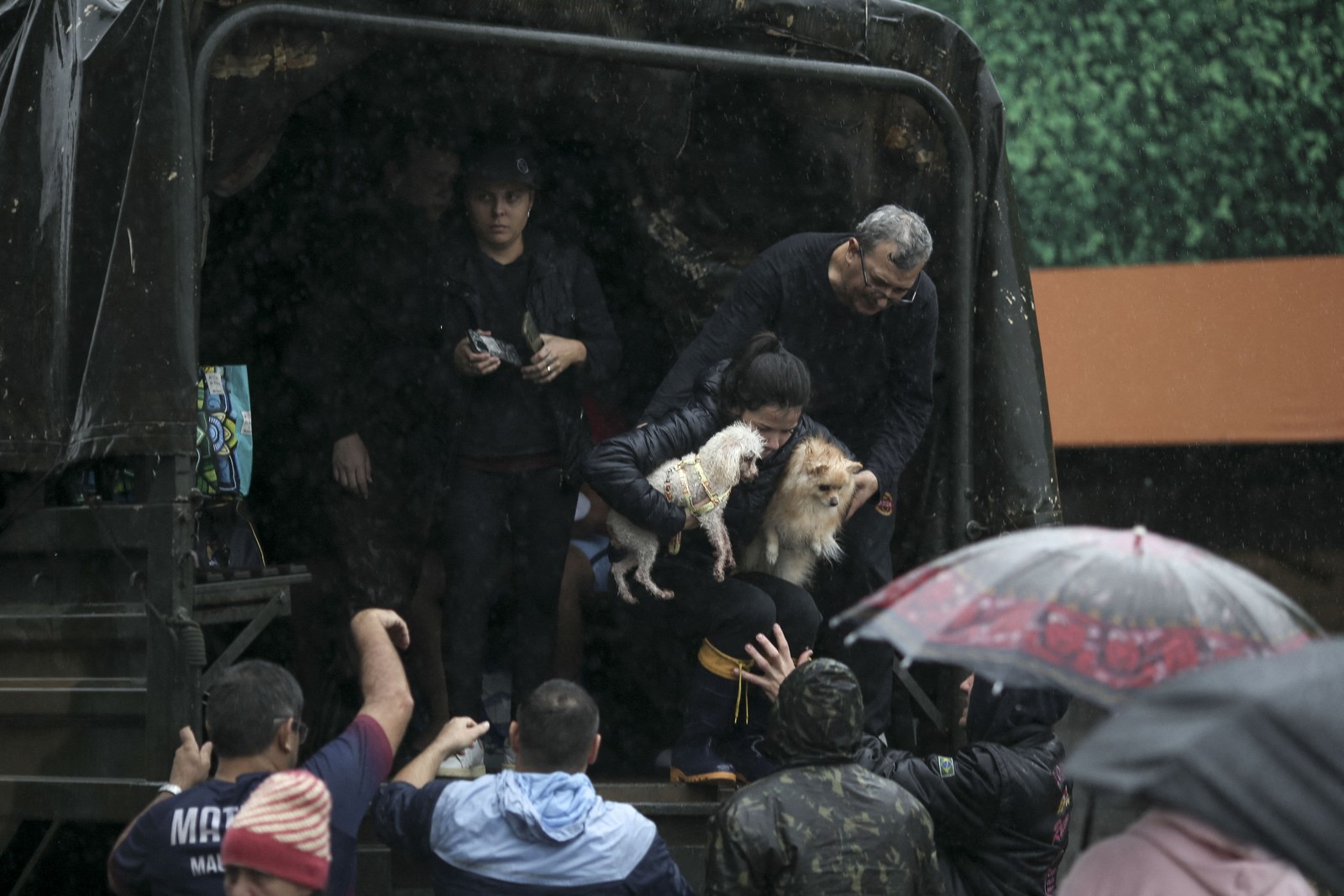 Mulher carrega seus cachorros junto a ela em resgate. — Foto: Anselmo Cunha / AFP