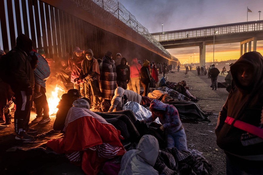 Imigrantes na fronteira em El Paso, no Texas, acendem fogueiras para se manterem aquecidos durante a frente fria polar que atingiu os Estados Unidos