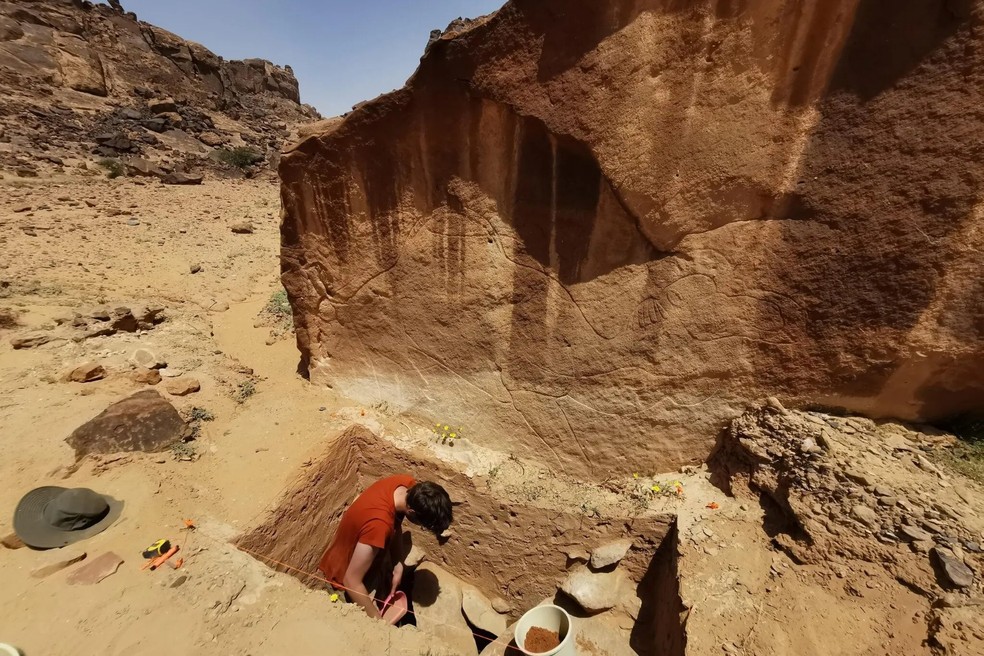Escavações na base de uma escultura de camelo em Jebel Arnaan, onde também foram descobertas ferramentas de gravação — Foto: Divulgação/Projeto de Arte Rupestre e Arqueologia de Sahout