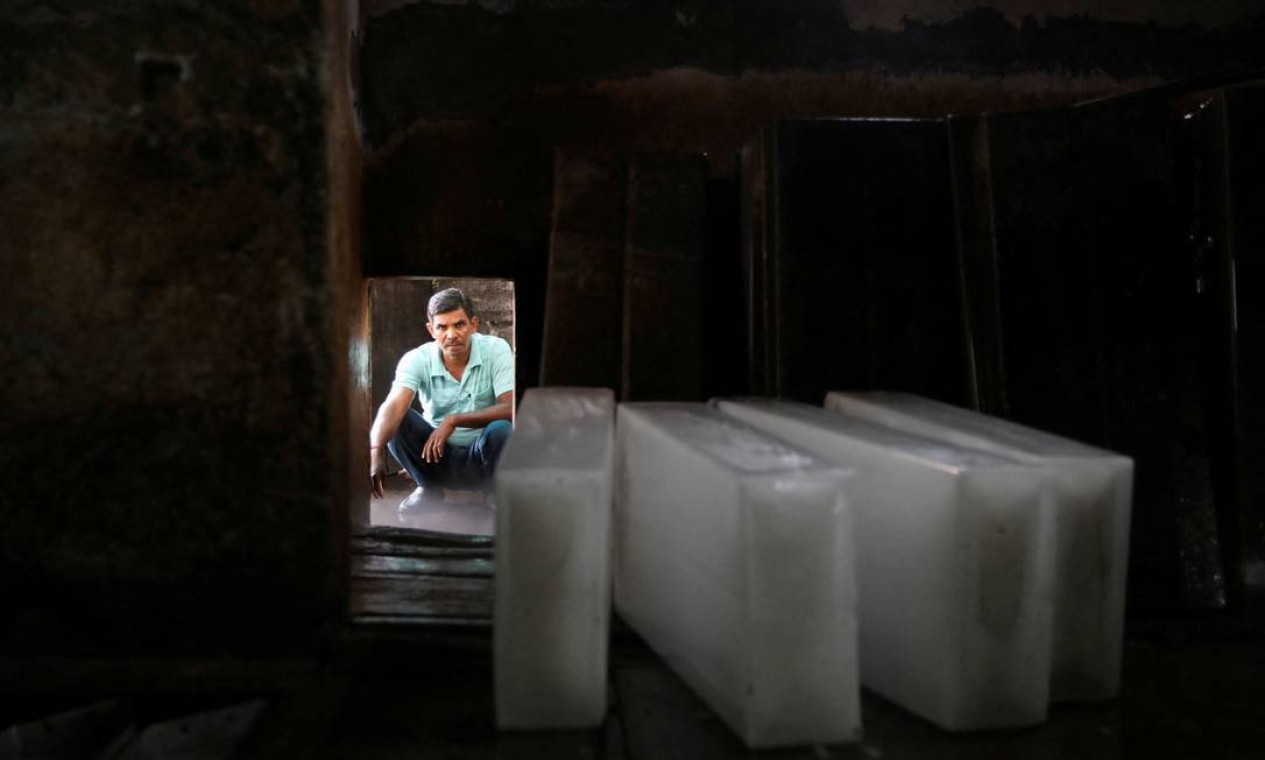 Homem espera para carregar blocos de gelo em um caminhão, em uma fábrica de gelo em Nova Délhi. Onda de calor atinge também áreas do Paquistão, afetando mais de 1 bilhão de pessoas ao todo  — Foto: ANUSHREE FADNAVIS / REUTERS