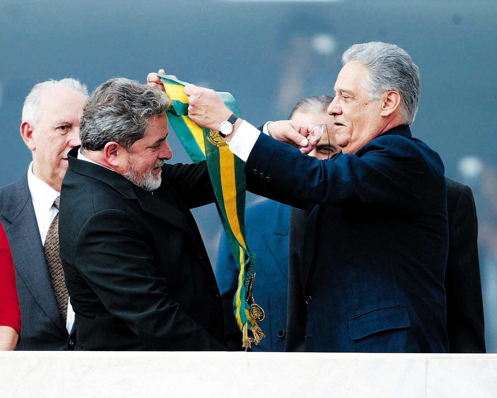 O presidente eleito Luiz Inácio Lula da Silva recebe de Fernando Henrique Cardoso a faixa de Presidente da República no Parlatório do Palácio do Planalto — Foto: Ivo Gonzalez / Agência O Globo