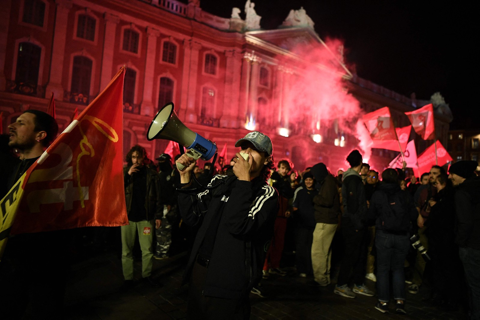 Manifestante usa um megafone na praça do Capitólio de Toulouse — Foto: Valentim CHAPUIS / AFP