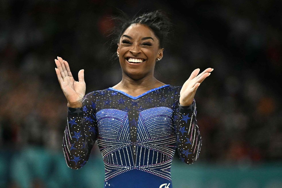 Simone Biles sorri e comemora após se apresentar na trave nas Olimpíadas de 2024 — Foto: Lionel BONAVENTURE / AFP