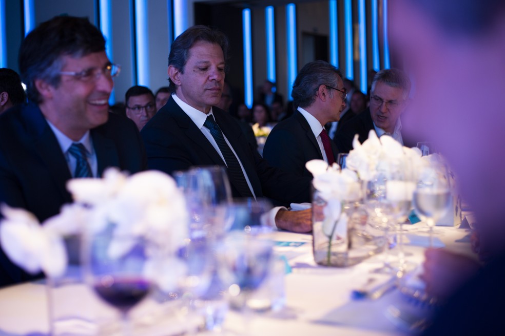Haddad em almoço na Febraban, ladeado pelo presidente da entidade, Isaac Sidney, e o banqueiro André Esteves, do BTG Pactual — Foto: Maria Isabel Oliveira/ Agência O Globo