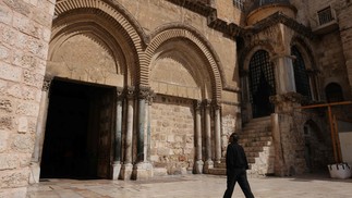 Homem caminha pela Igreja do Santo Sepulcro, na Antiga Jerusalém — Foto: Ahmad Gharabli/AFP