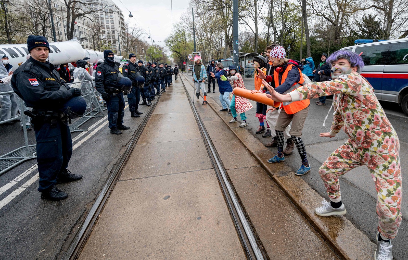 Policiais observam manifestantes durante um protesto em Viena, Áustria, enquanto a capital sedia a Conferência Europeia do Gás — Foto: JOE KLAMAR / AFP