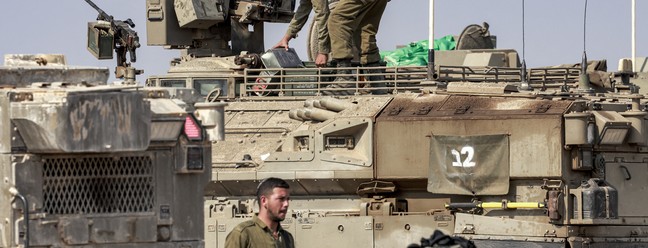 Soldados circulam entre tanques 1500, os mais recentes das forças de Israel — Foto: AFP