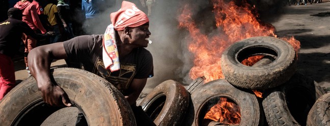 Manifestantes fazem barricada em chamas em Kibera, Nairóbi, em protesto contra crise política e econômica que assola o país — Foto: YASUYOSHI CHIBA