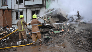 Bombeiros apagando incêndio em prédio após ser atingido por míssil, em Poltava, na Ucrânia — Foto: Sergey Bobok / AFP