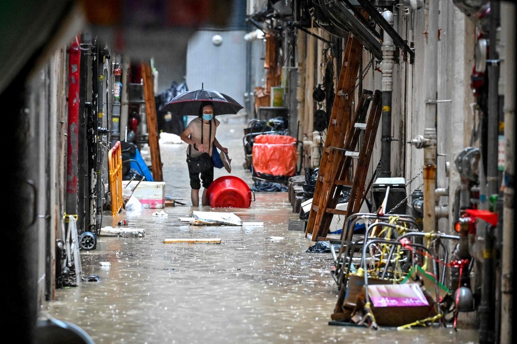 Uma mulher caminha em um beco inundado em Hong Kong — Foto: Mladen ANTONOV / AFP