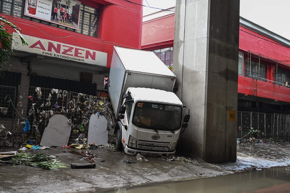 Caminhão foi jogado contra a cerca de uma loja durante a tempestade provocada pelo tufão Gaemi, em Manila — Foto: Jam Sta Rosa / AFP