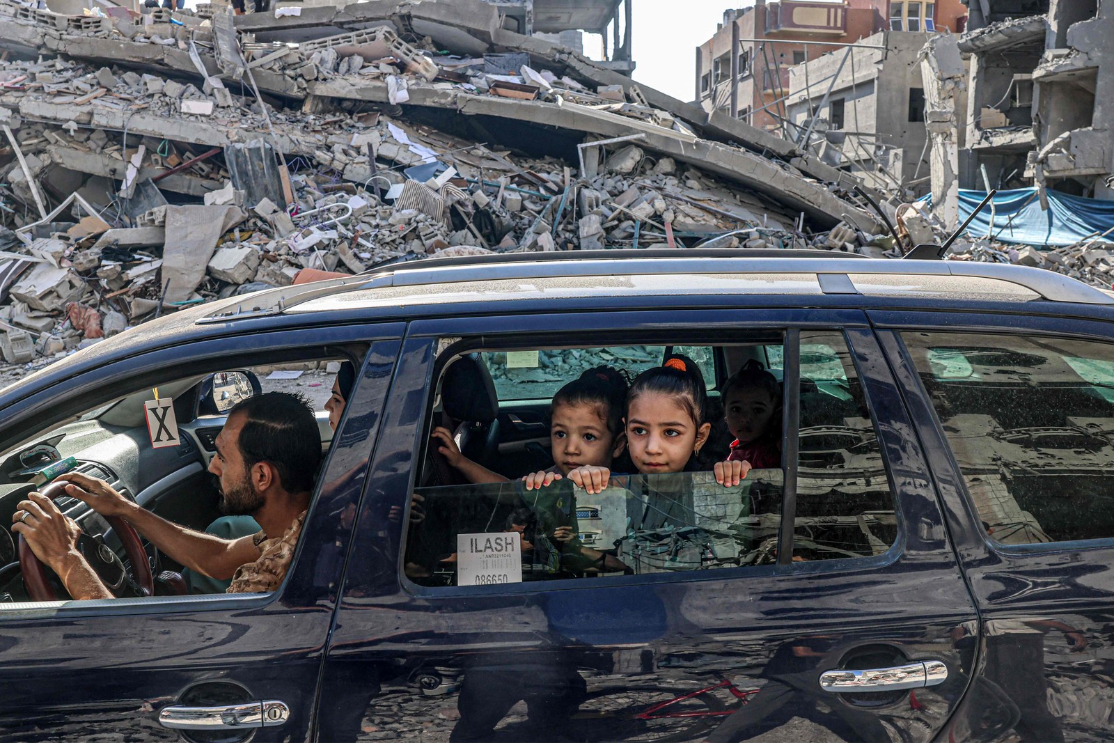 Carro com crianças em meio aos destroços na Faixa de Gaza — Foto: Said Khatib/AFP