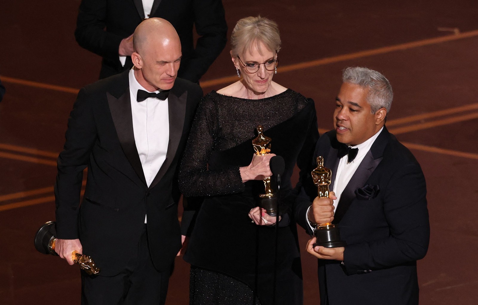 Gareth John, Gwendolyn Yates Whittle e Juan Peralta aceitam o prêmio de Melhor Som por "F1". — Foto: PATRICK T. FALLON