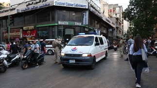 Após explosões de pagers em Beirute, no Líbano, soldados do exército libanês fazem guarda enquanto ambulância transporta feridos — Foto: Anwar AMRO / AFP