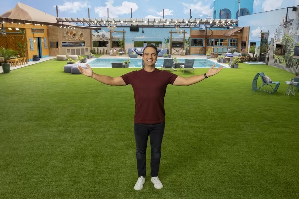 O radialista Tadeu Schmidt com a casa do BBB 25 ao fundo – Foto: Fábio Rocha/Rede Globo