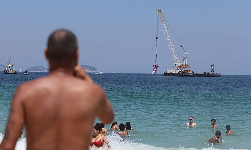 Banhistas acompanharam o avião sendo retirado da água — Foto: Fabiano Rocha/Agência O Globo