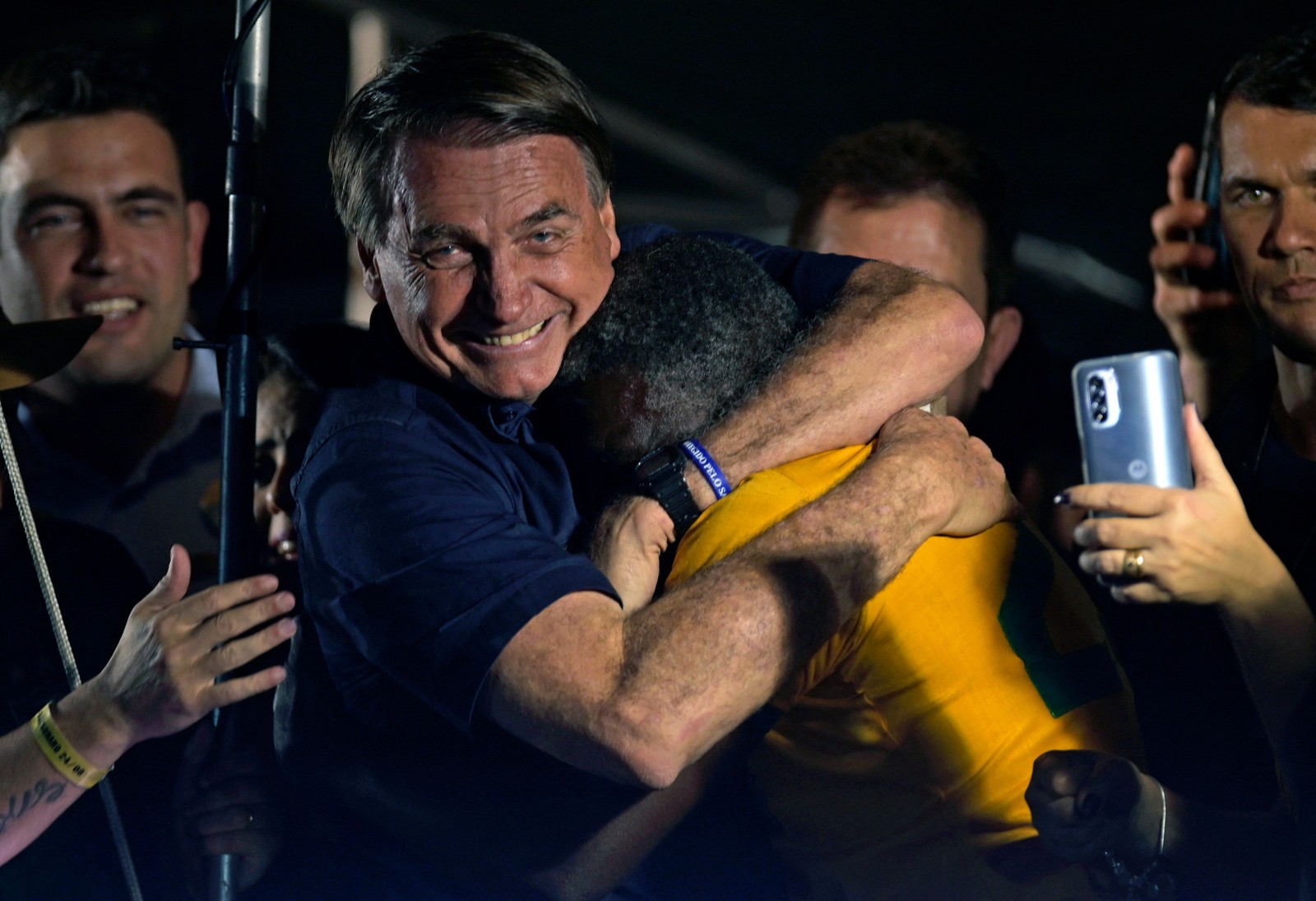 Flopou. Jair Bolsonaro abraça um dos poucos apoiadores após participar de um comício como parte de sua campanha à reeleição, na Praça da Liberdade, em Belo Horizonte, Minas Gerais  — Foto: DOUGLAS MAGNO / AFP
