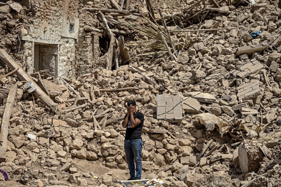 Um voluntário se emociona ao ajudar nas buscas por sobreviventes do terremoto que atingiu o Marrocos — Foto: Fadel Senna / AFP
