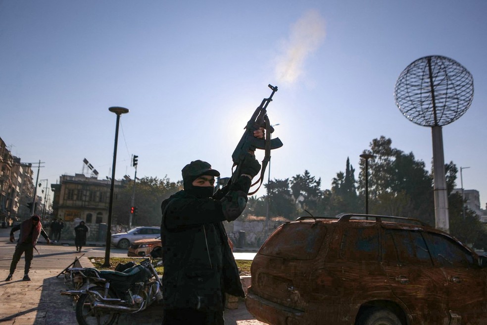 Um combatente antigovernamental dispara para o alto no centro de Aleppo, depois de jihadistas e seus aliados terem entrado na cidade do norte da S&iacute;ria &mdash; Foto: AAREF WATAD / AFP