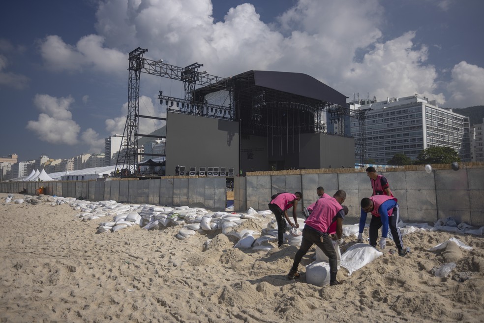 Equipe da organização do espetáculo fez a remoção dos sacos de areia utilizados por fãs da Lady Gaga — Foto: Marcia Foletto