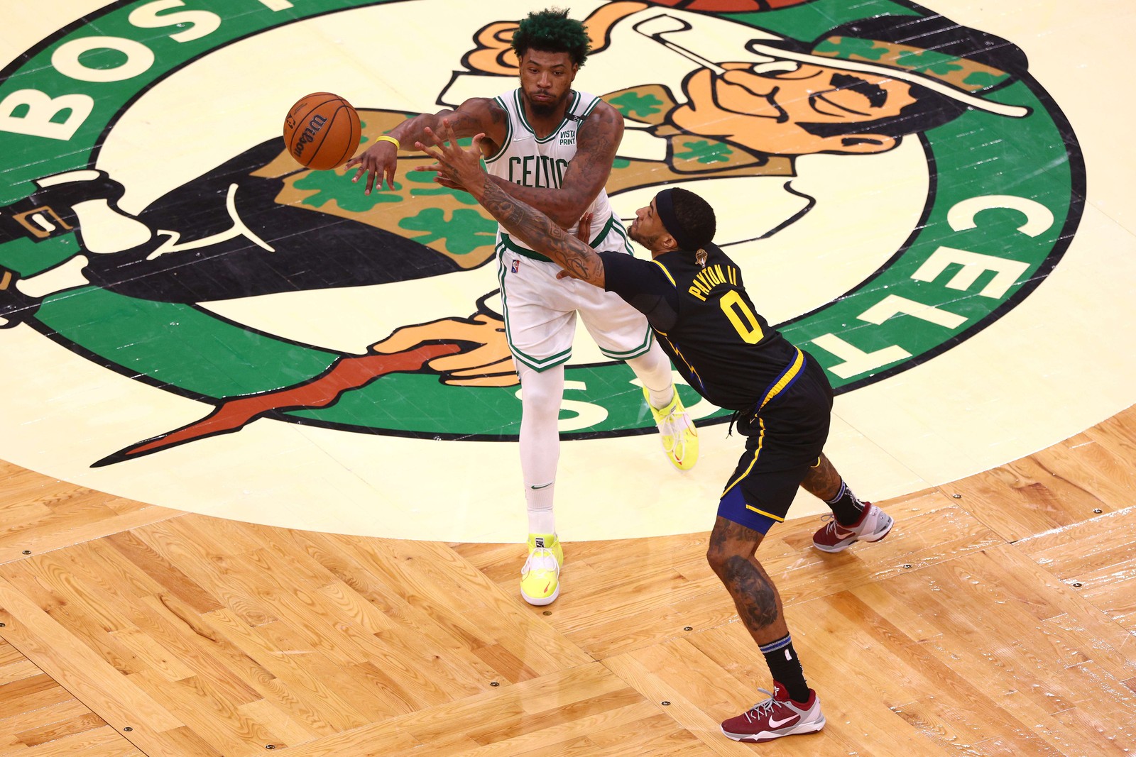 Marcus Smart, do Boston Celtics, passa a bola defendida por Gary Payton, do Golden State Warriors, no quarto trimestre durante o jogo três das finais da NBA de 2022 — Foto: EZRA SHAW/Getty Images/AFP