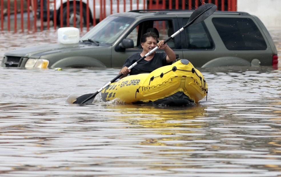 Homem Rema em U, Caiaque Por AvenidaInundadaApósOTransbordamento Do Rio Arroyo seco seco em tlajomulcode Zúñiga, Mexico - foto: Ulises Ruiz / AFP