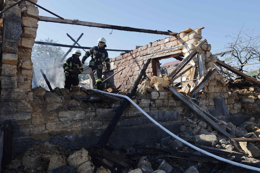 Socorristas ucranianos trabalham do lado de fora de uma casa destruída após um ataque aéreo russo em uma vila na região de Odessa, antes do acordo de grãos, em 19 de julho de 2022, em meio à invasão militar russa da Ucrânia.
