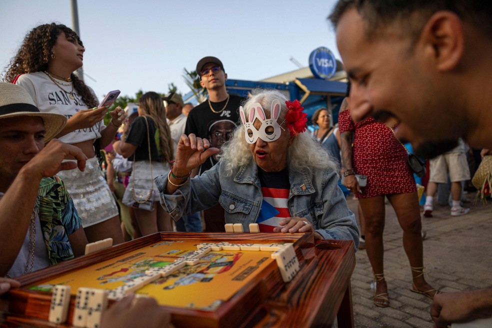 Jogo de dominó nas imediações do Coliseo, onde acontecem os shows de Bad Bunny — Foto: Ricardo ARDUENGO / AFP