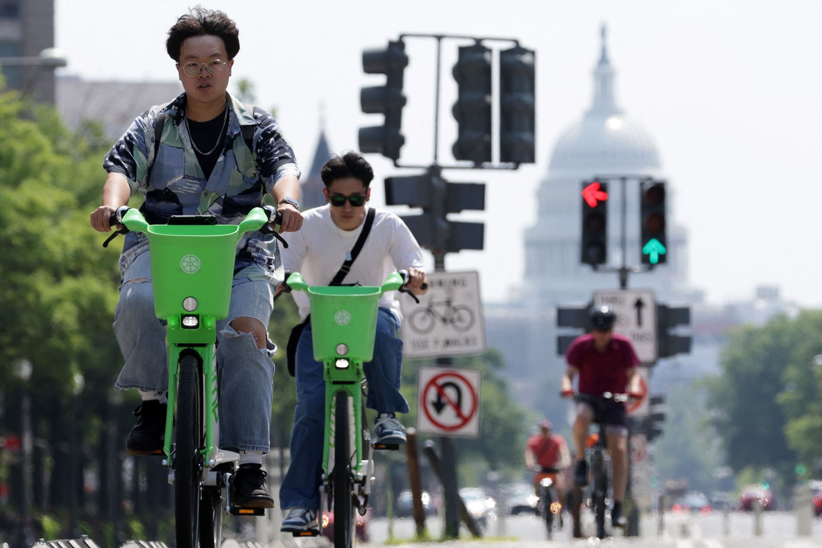 Pessoas andam de bicicleta na Avenida Pensilvânia em 28 de julho de 2023, em Washington — Foto: ALEX WONG / Getty Images via AFP