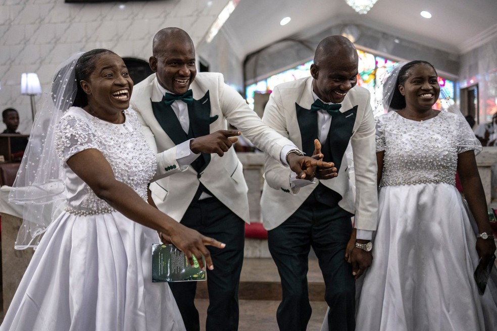 Noivos e noivas dançam durante a cerimônia de casamento na Igreja Anglicana Memorial Bishop Akinyele, em Ibadan, em 20 de junho de 2026. — Foto: AFP