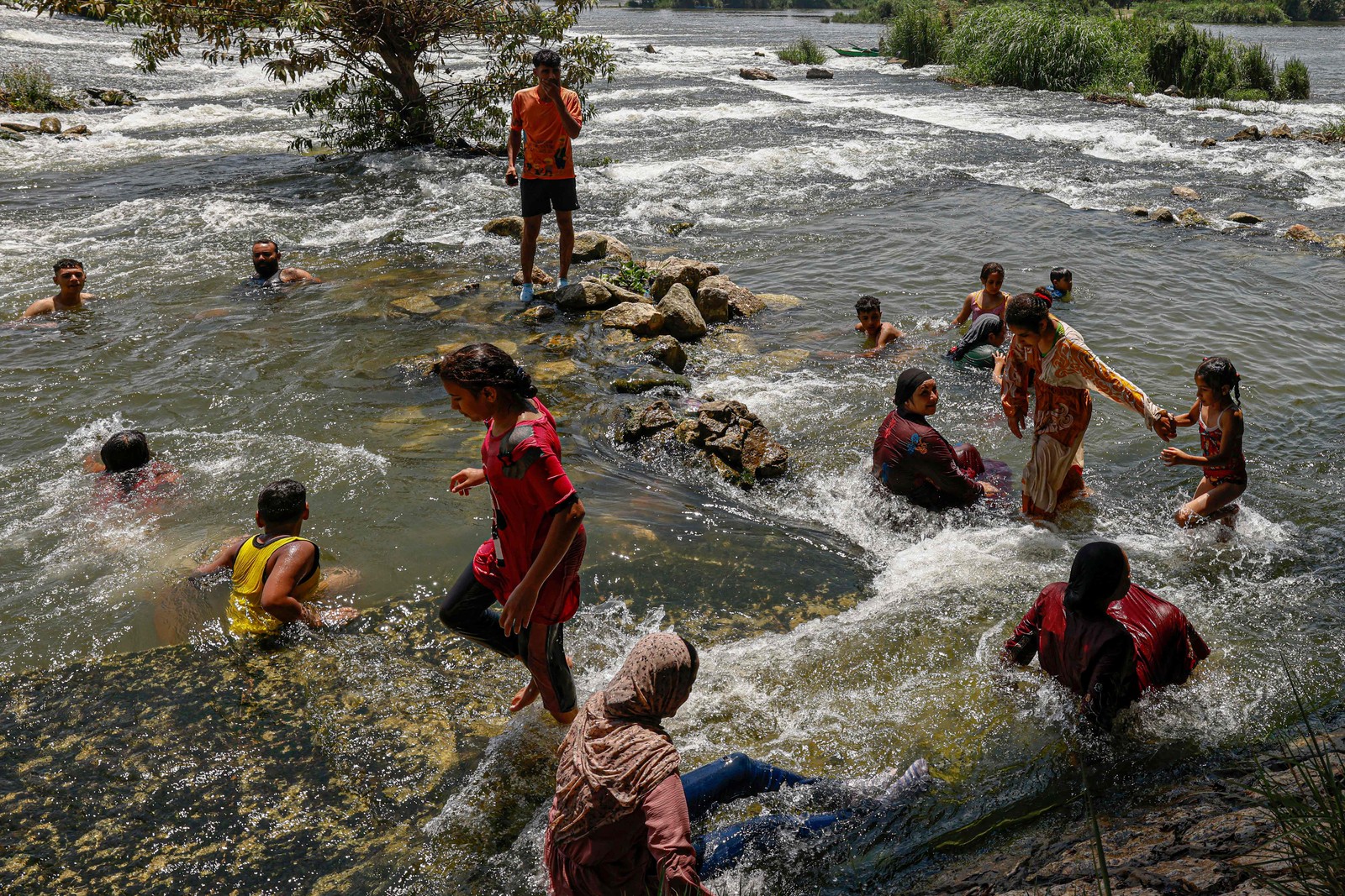 Pessoas se refrescam no rio Nilo durante onda de calor em al-Qanater al-Khayreya, nos arredores do Cairo.  — Foto: Khaled DESOUKI / AFP