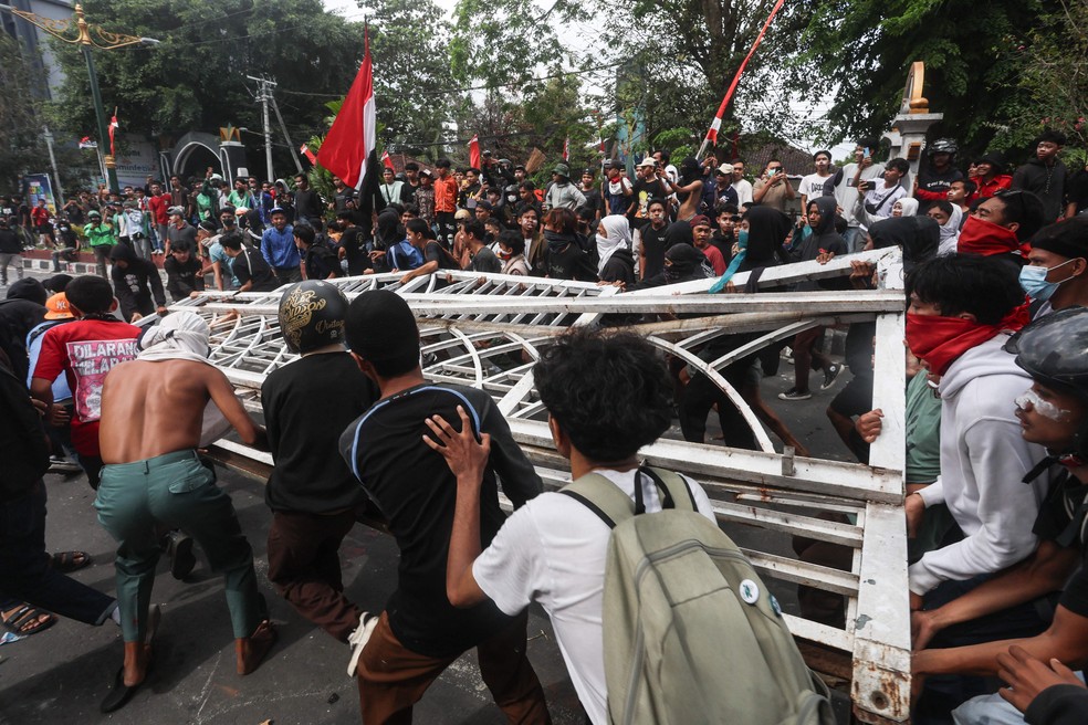 Manifestantes derrubam a cerca do escritório do Conselho Provincial de West Nusa Tenggara durante uma manifestação em Mataram, na Ilha de Lombok — Foto: AFP