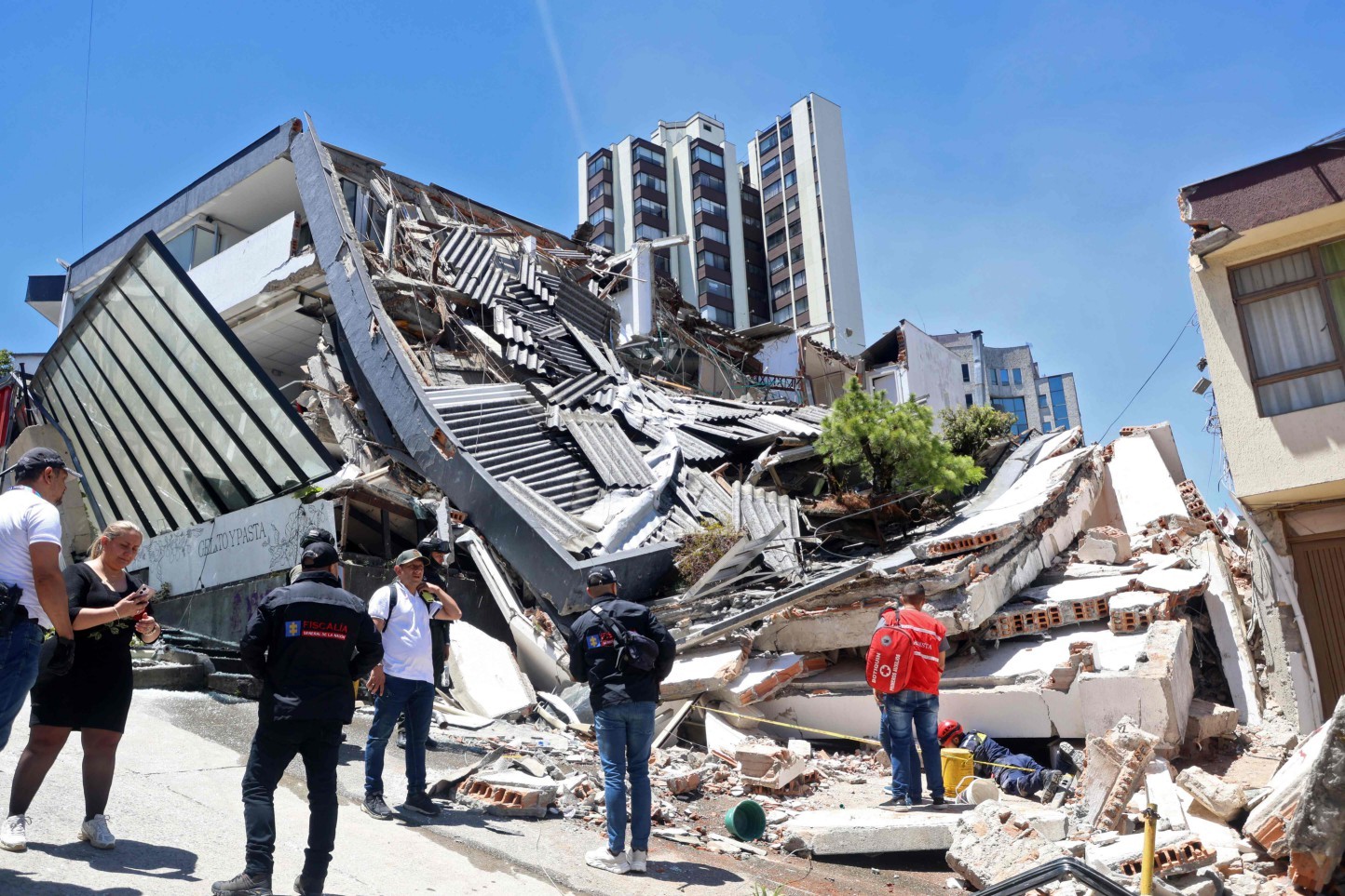 Pessoas permanecem perto de um edifício desabado após um terremoto em Manizales, Colômbia.. — Foto: Giovanny Galvez / AFP