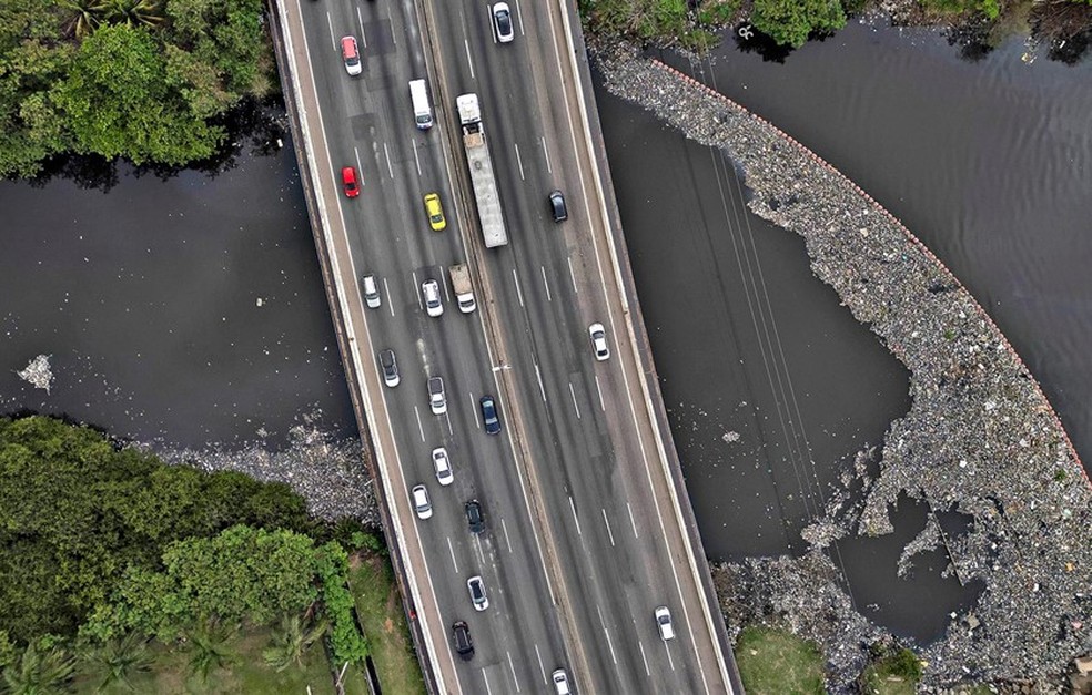 Sem controle. Esgoto e lixo tomam o Rio Pavuna, que passa sob a Rodovia Washington Luís, em Caxias — Foto: Márcia Foletto