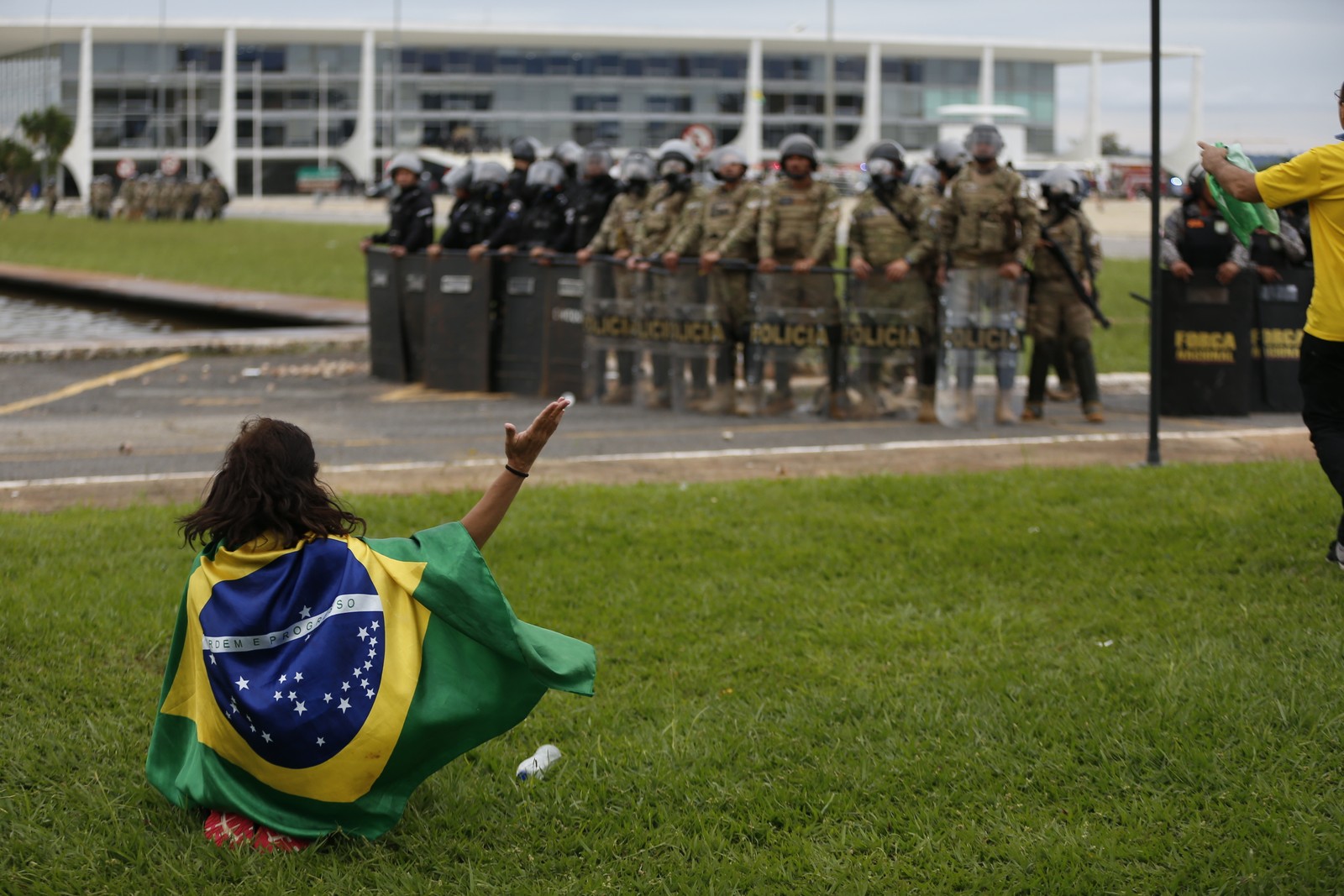 Policiais observam manifestantes na região da Praça dos Três Poderes — Foto: Cristiano Mariz/Agência O Globo