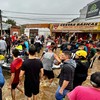 Esta foto divulgada pela Prefeitura de Canoas, município do Rio Grande do Sul, mostra equipes de resgate e voluntários ajudando vítimas de enchentes. - Alisson Moura / Prefeitura de Canoas / AFP
