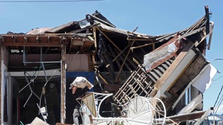Um homem carrega uma bolsa saindo de uma construção desabada após um terremoto em Manizales, Colômbia, em 10 de agosto de 2026. — Foto: Giovanny Galvez / AFP