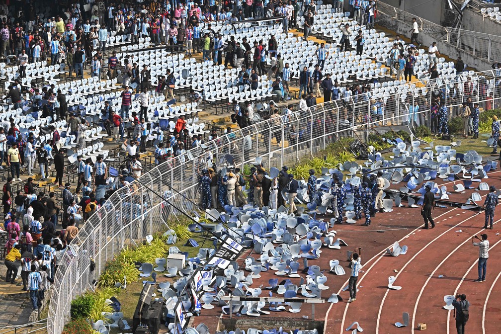Supporters throw chairs onto the pitch after Messi's quick appearance on tour of India — Photo: Dibyangshu SARKAR / AFP