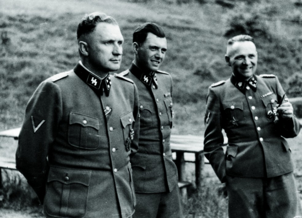 Josef Mengele, no centro, no campo de extermínio de Aushcwitz, durante uma guerra — Foto: Reprodução