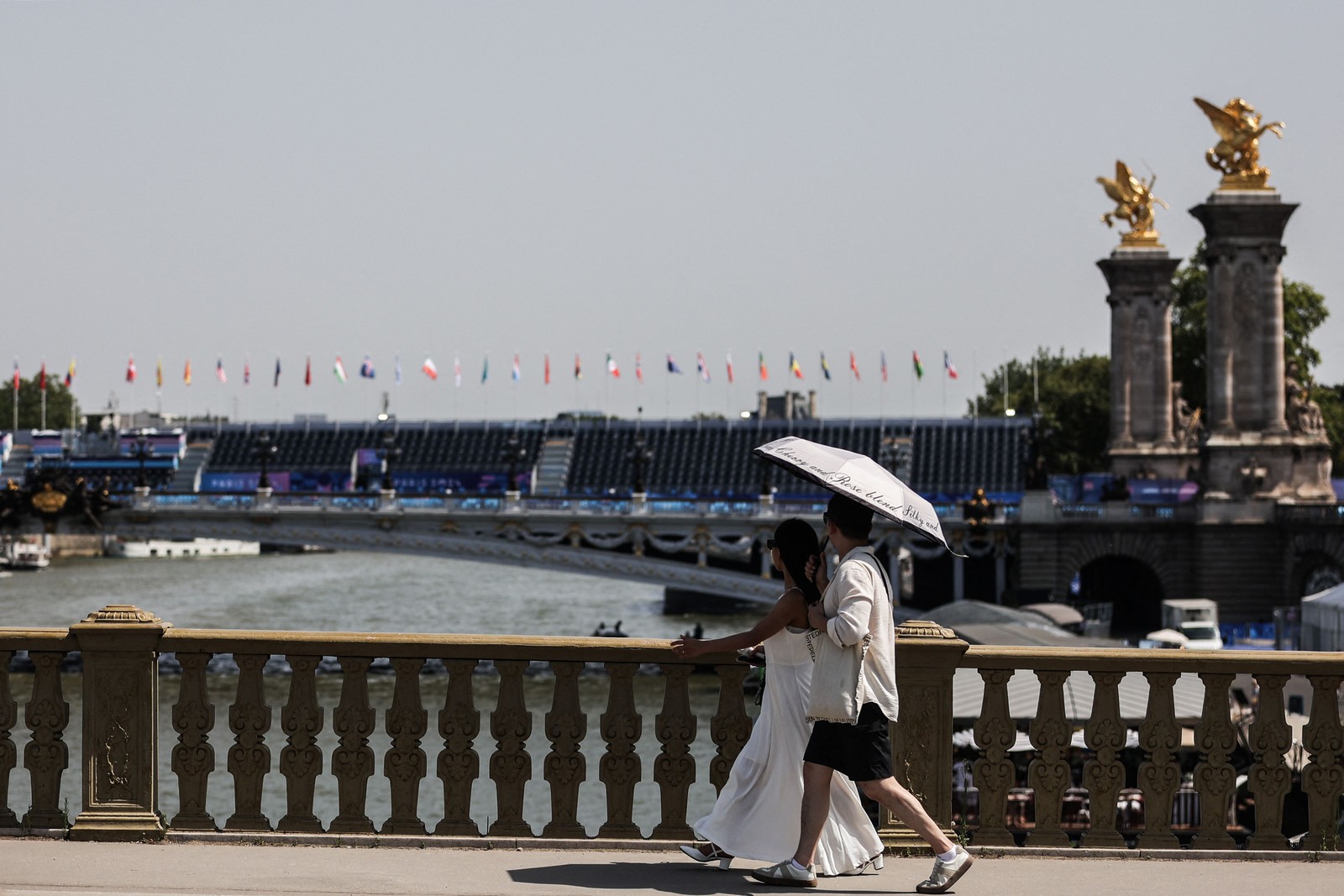 A couple walks along the banks of the Seine — Photo: Thibaud MORITZ/AFP
