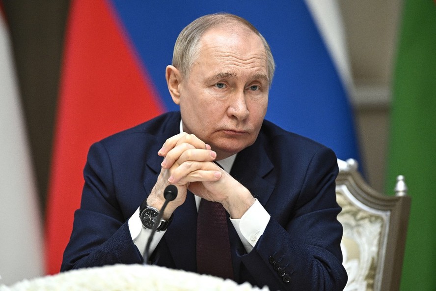O presidente da Rússia, Vladimir Putin, observa enquanto o presidente do Uzbequistão faz declaração à mídia, em 27 de maio de 2024