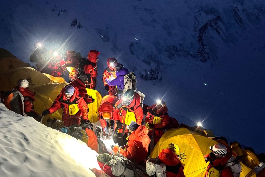 Foto irada em 19 de maio de 2026 mostra montanhistas deixando o Acampamento 3 para continuar a subida ao cume do Monte Everest, no Nepal.
