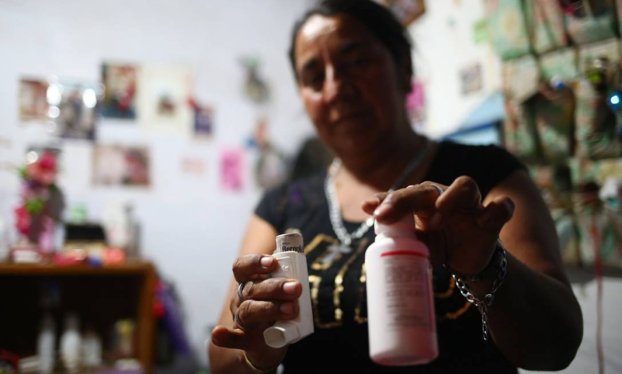 A chilena Alejandria Arriaza mostra os remédios da neta, Deyanira, de quase dois anos. No ano passado, uma nuvem tóxica cobriu o céu e oito de seus familiares adoeceram, durante a última grande emergência ambiental, entre agosto e setembro — Foto: PABLO VERA / AFP