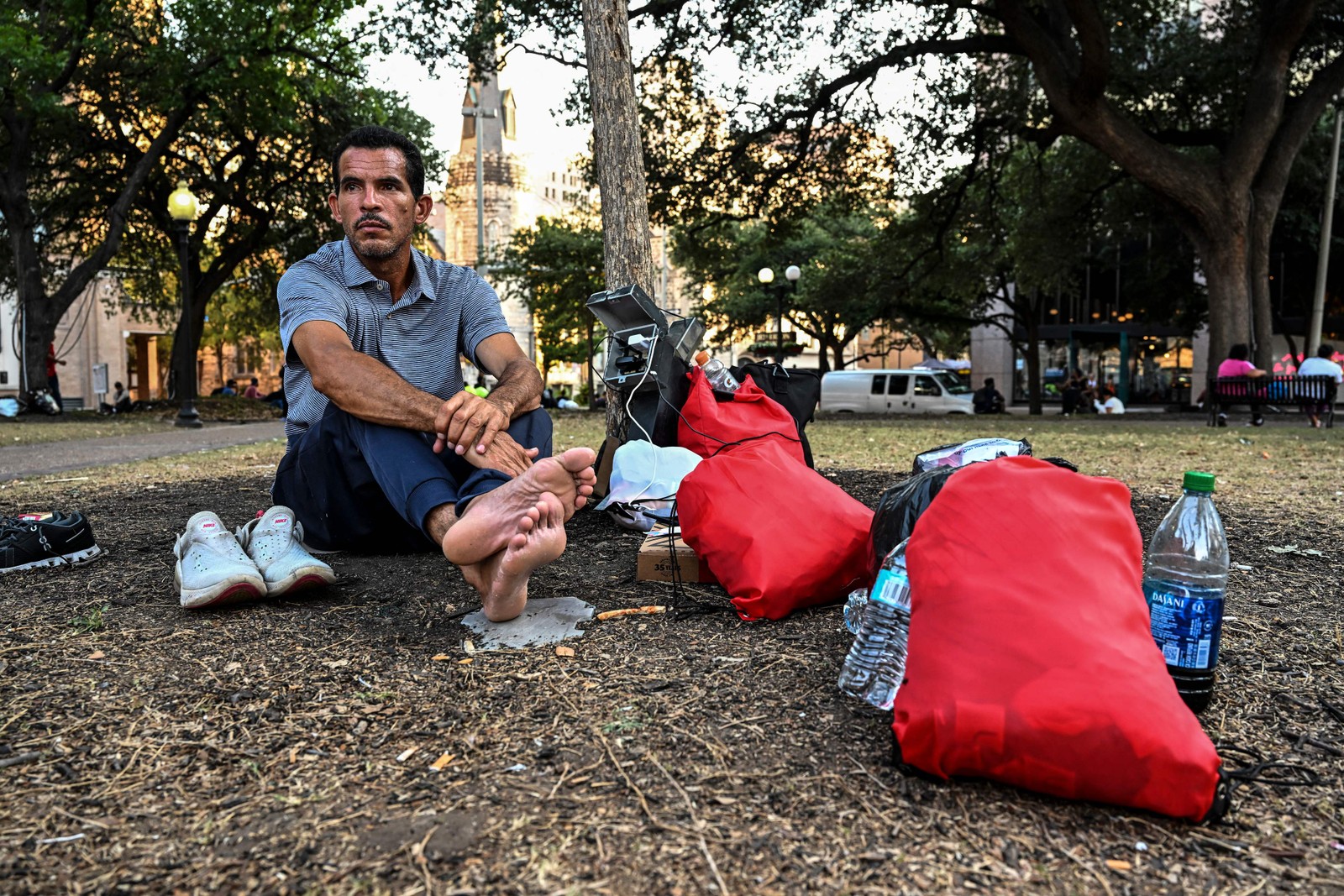 Imigrante espera em um parque perto de um abrigo em San Antonio. Seja qual for o caminho usado para cruzar a fronteira, se passaram pelo nordeste do México, há uma boa chance de que passem por San Antonio, cidade de quase 1,5 milhão de pessoas. — Foto: CHANDAN KHANNA / AFP