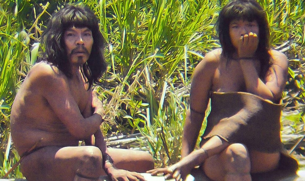 Mashco Piro sentados na beira de um rio perto do Parque Nacional Manú, Peru, em 2011 — Foto: Survival International