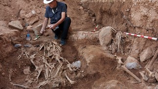 O paleoantropólogo José Ignacio Lorenzo exuma os restos mortais de pessoas mortas entre 1936 e 1939 durante a Guerra Civil Espanhola no cemitério de Belchite, perto de Saragoça  — Foto: CESAR MANSO / AFP